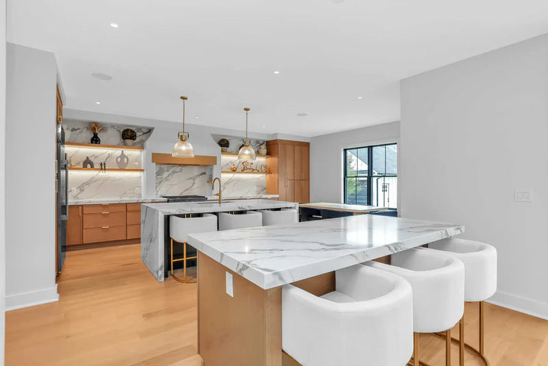Bright modern kitchen with white cabinets, large island, and natural light - Captivating Cabinets
